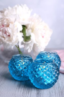 cam şamdanlar ve çiçek renk ahşap zemin üzerinde