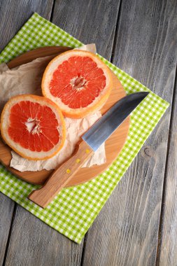 Olgun greyfurt ve ahşap zemin üzerinde kesme tahtası üzerinde bıçak