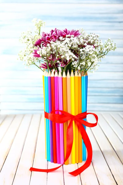 Bellissimi fiori in colorato vaso di matite su sfondo di legno — Foto Stock