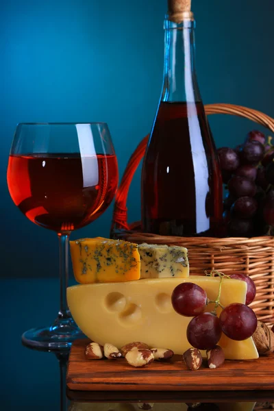 Vinho rosa, uvas e queijo sobre fundo colorido — Fotografia de Stock