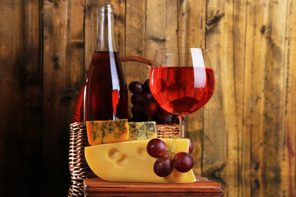 Vino rosa, uvas y queso sobre fondo de madera —  Fotos de Stock