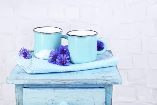 Чашки молока и васильков на деревянном столе — стоковое фото