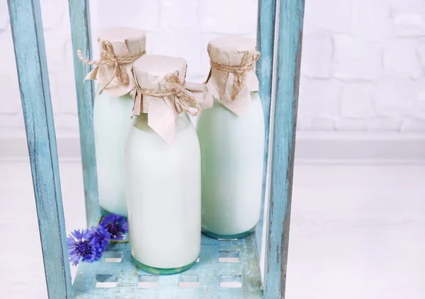 Garrafas de leite e flores de milho na mesa de madeira — Fotografia de Stock