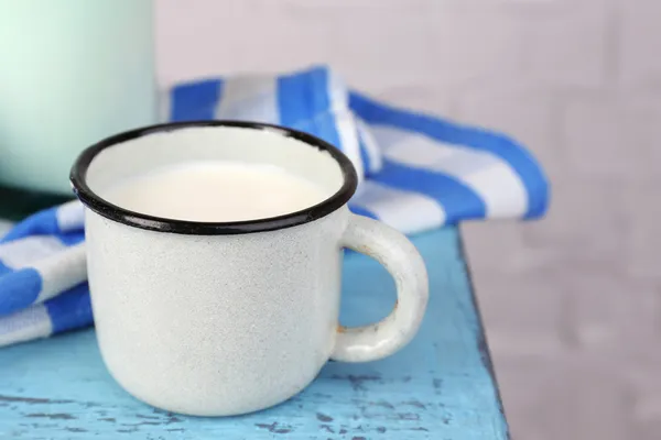 Kopp och en flaska mjölk och blåklint på träbord — Stockfoto