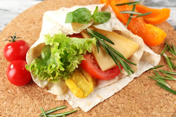 Enveloppement végétarien rempli de poulet et de légumes frais sur une table en bois, fermer — Photo