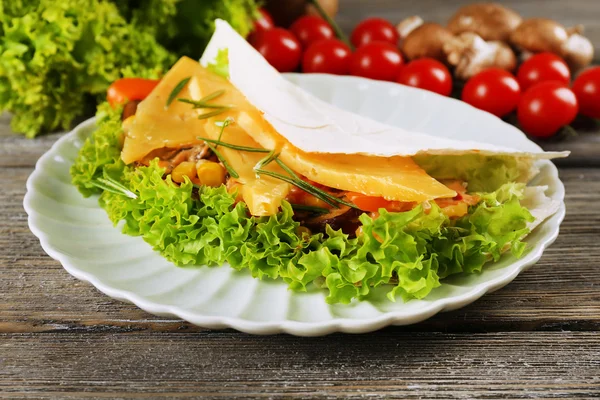 Veggie wrap filled with cheese and fresh vegetables on wooden table, close up — Stock Photo, Image