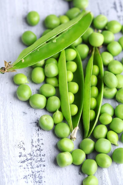 Guisantes verdes frescos sobre fondo de madera — Foto de Stock