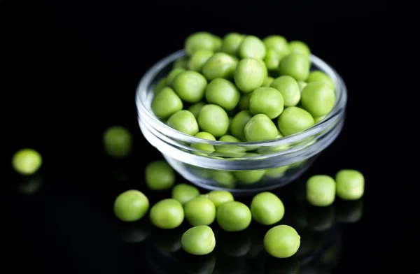 Ervilhas verdes frescas em tigela isoladas em fundo preto — Fotografia de Stock