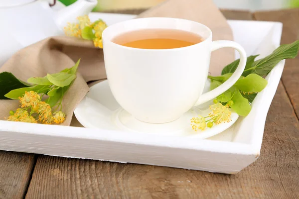 Sabroso té de hierbas con flores de tilo en la mesa de madera —  Fotos de Stock