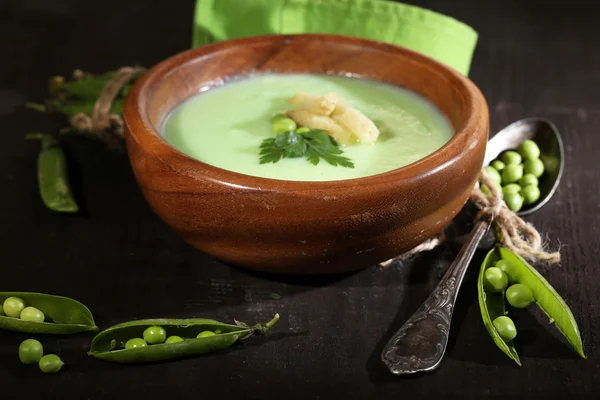 Sabrosa sopa de guisantes en mesa de madera con luz oscura — Foto de Stock