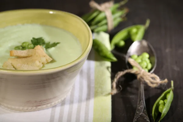 Tasty peas soup on wooden table with dark light — Stock Photo, Image