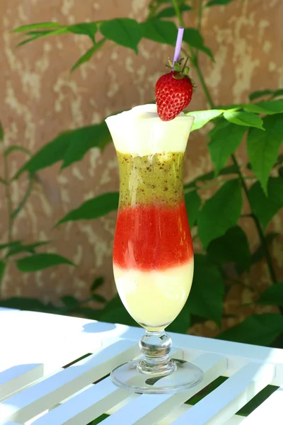 Delicious fruit smoothie on white table, outdoors — Stock Photo, Image