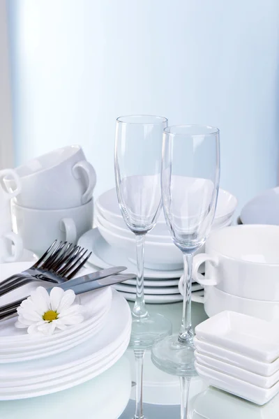 Σετ λευκά πιάτα στο τραπέζι επάνω ελαφρύς υπόβαθρο — Φωτογραφία Αρχείου