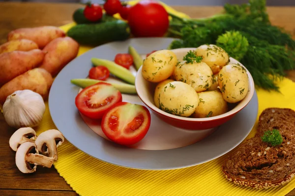 Młode ziemniaki gotowane z warzywami na stole, z bliska — Zdjęcie stockowe