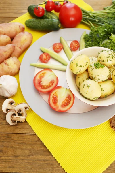 Unga kokt potatis med grönsaker på bordet, närbild — Stockfoto