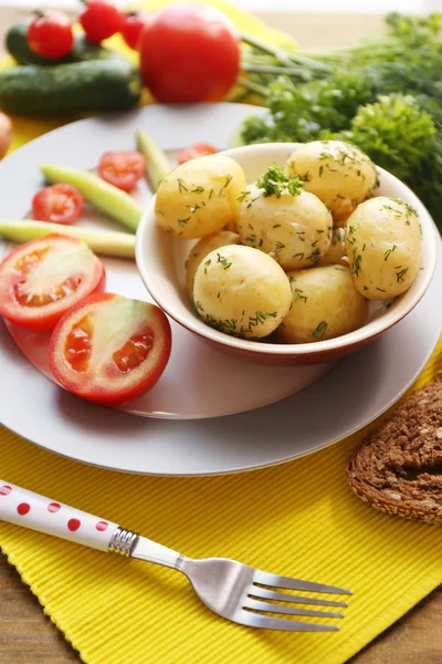 Jonge gekookte aardappelen in pan op houten tafel — Stockfoto