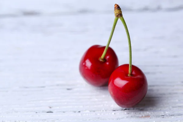 Cerejas doces na cor de fundo de madeira — Fotografia de Stock