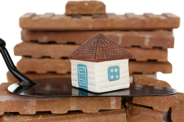 Wooden toy house on trowel and tiles, close up Stock Picture