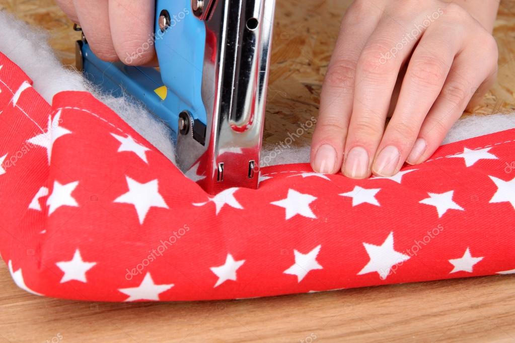 Fastening fabric and board using construction stapler — Stock Photo