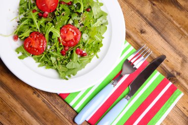 roka, domates ve susam ahşap zemin üzerinde plaka üzerinde yapılmış yeşil salata