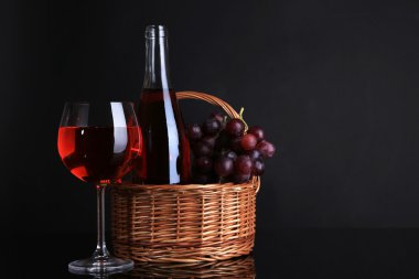 Olgun üzüm, Şarap kadehi ve siyah arka plan üzerine şarap şişe