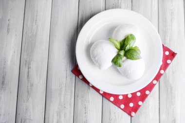 lezzetli mozzarella peyniri Fesleğenli ahşap zemin üzerinde plaka üzerinde