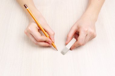 insan eli ile ahşap masa arka plan üzerinde kalem ve silme lastik