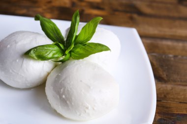lezzetli mozzarella peyniri Fesleğenli ahşap zemin üzerinde plaka üzerinde