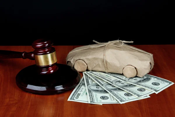 Gavel, modèle de voiture et de l'argent sur la table sur fond noir — Photo