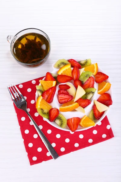 Divers fruits tranchés dans une assiette sur la table close-up — Photo