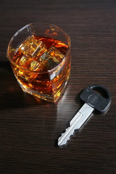 Composition with car key and glass of whiskey, on wooden background — Stock Photo, Image