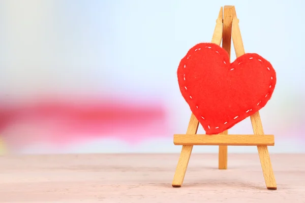 Beautiful heart  small decorative easel on pink table — Stock Photo, Image