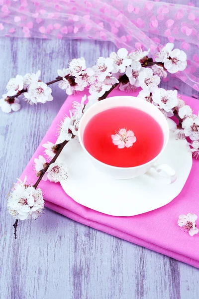 木製のテーブルのクローズ アップの開花枝と香りのよい紅茶 — ストック写真