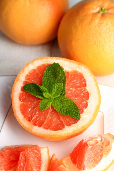 Rijp grapefruits op plaat op een houten achtergrond kleur — Stockfoto