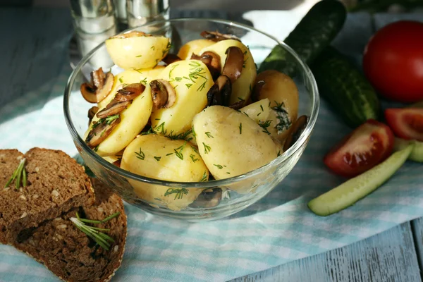 Jeunes pommes de terre bouillies dans un bol sur une table en bois, gros plan — Photo