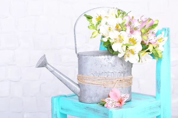 部屋の椅子に水まき缶で freesias の美しい花束 — ストック写真