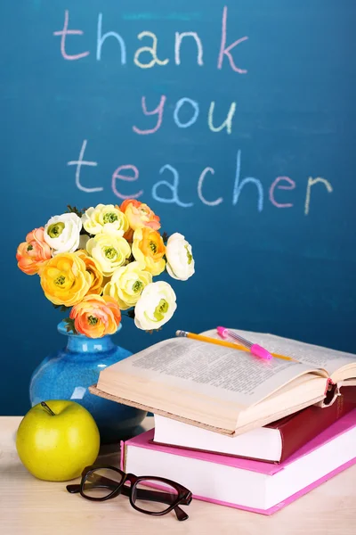 Fournitures scolaires et fleurs sur fond tableau noir avec inscription Merci professeur — Photo