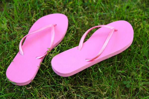Bright flip-flops on green grass — Stock Photo, Image