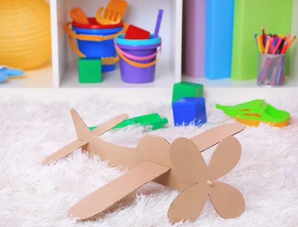 Juguete de avión de papel en la habitación en la alfombra —  Fotos de Stock