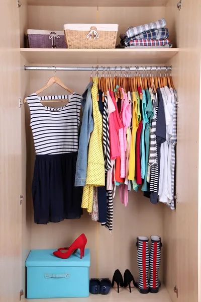 Colorful clothes hanging in wardrobe — Stock Photo, Image
