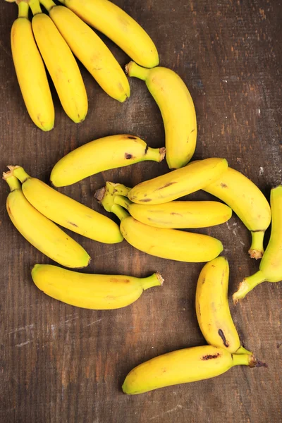 Bunch of mini bananas on color wooden background — Stock Photo, Image