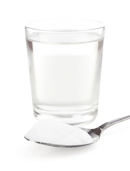 Spoon of baking soda over glass of water, isolated on white — Stock Photo, Image