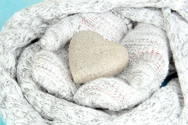 Female hands in mittens with heart on wooden background