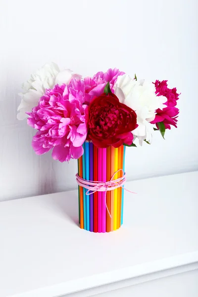 Smukke blomster i farverige blyanter vase i indretning - Stock-foto