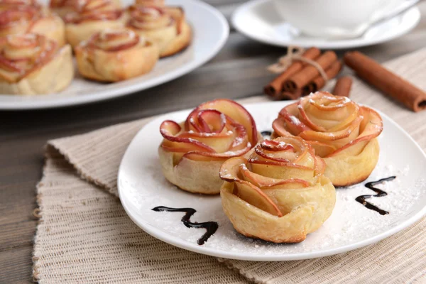 Välsmakande smördeg med apple formade rosor på tallriken på bordet närbild — Stockfoto