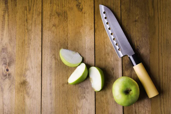 Kitchen knife and green apple,   on wooden background — Stock Photo, Image