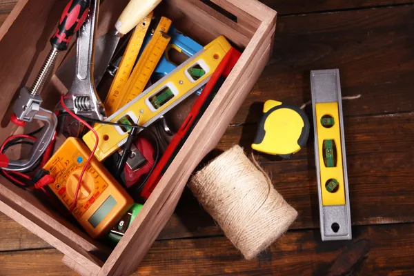 Caixa de madeira com diferentes ferramentas, em fundo de madeira rústica — Fotografia de Stock