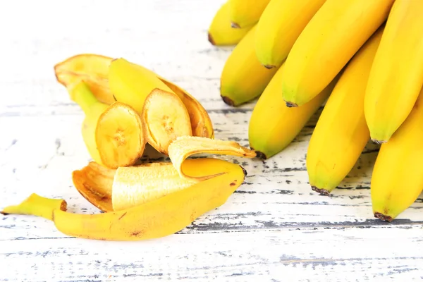 Bunch of mini bananas on color wooden background — Stock Photo, Image