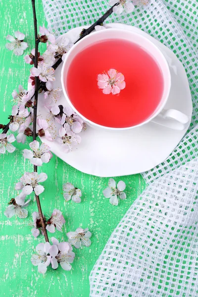 Fragrant tea with flowering branches on wooden table close-up — Stock Photo, Image