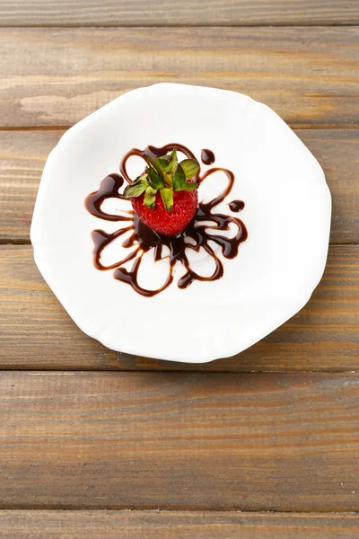 ahşap masa üstünde çikolata ile kırmızı olgun çilek